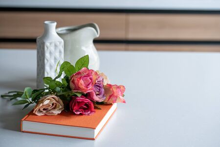 Artificial antique roses on kitchen table. Quiet and cozy kitchen concept.の写真素材