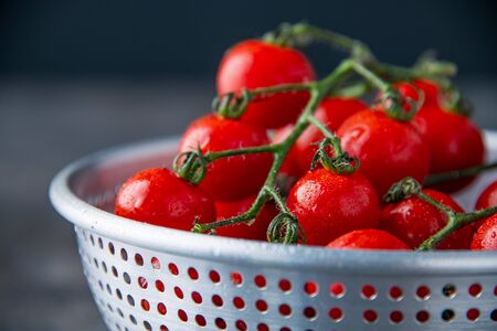 Fresh cherry tomatoes in colander.の写真素材