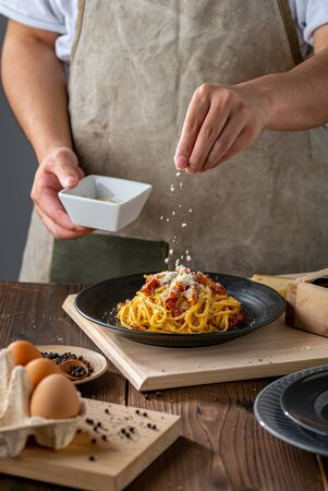 Delicious pasta carbonara on black plate.の写真素材