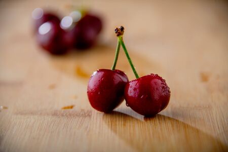 Ripe red cherries on wood background.の写真素材