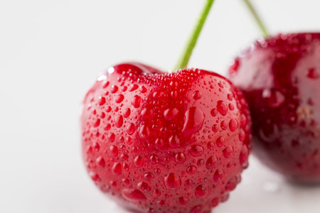 Ripe red cherries on white background.