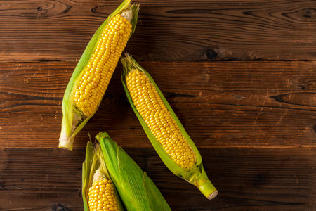 Corn cobs on wood background.