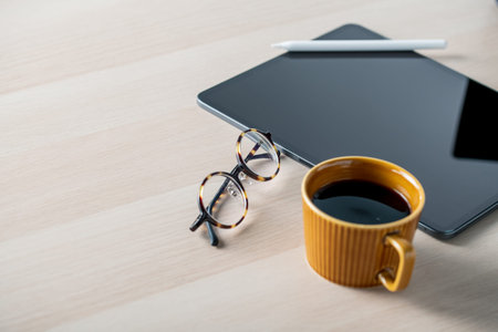 Digital tablet on table with stylus pen,cup of coffee,eyeglasses.
Technology lifestyle image.