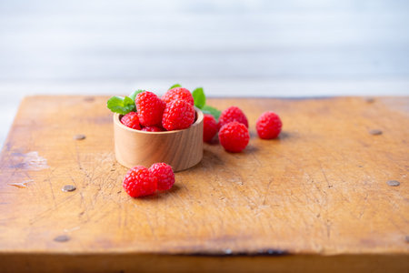 Fresh raspberries on wooden board.