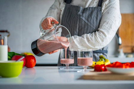 Close-up of a woman preparing a smoothie in the kitchenの写真素材