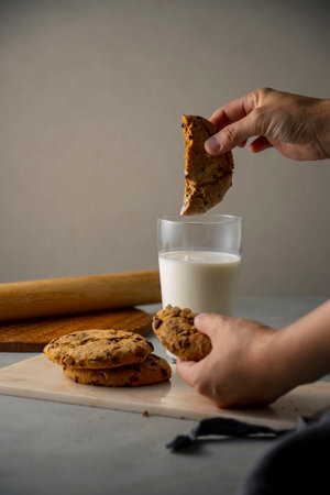 Dip a chocolate chip cookie in milk.
Sweet chocolate chip cookie picture.の写真素材