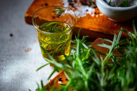 Rosemary, Salt, and Olive Oil. Fresh rosemary, rock salt, and olive oil on a cutting board, perfect for culinary themes.の写真素材
