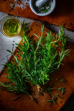 Rosemary, Salt, and Olive Oil. Fresh rosemary, rock salt, and olive oil on a cutting board, perfect for culinary themes.の写真素材