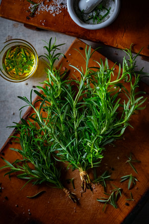 Rosemary, Salt, and Olive Oil. Fresh rosemary, rock salt, and olive oil on a cutting board, perfect for culinary themes.の写真素材