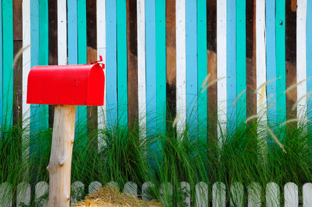 Red mailbox on a multicolored lath background.の写真素材