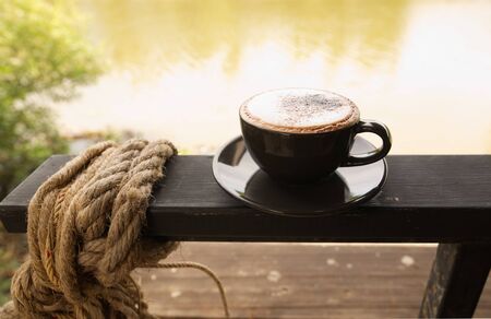 Hot mocha coffee or Cappuccino in the brown cup on the wooden table.の写真素材