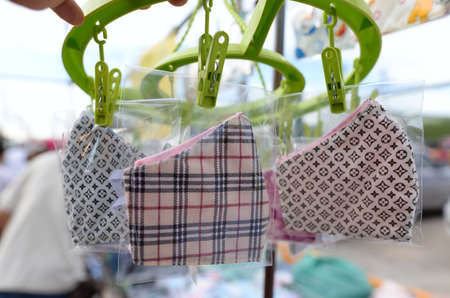 Many face masks of various colors are packed in clear plastic bags on the stall.のeditorial素材