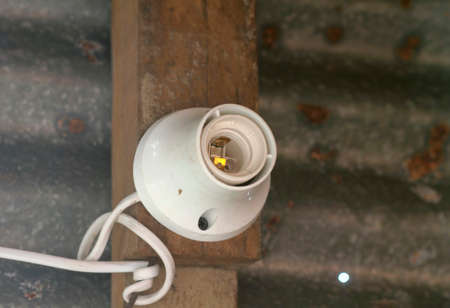 Lamp holder is mounted on wood and old zinc blurred background.の写真素材