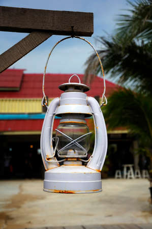 A gray oil lamp hanging under a wooden beam, On a blureed background.の写真素材