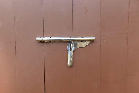 Stainless steel latch on the brown wood floor.の写真素材