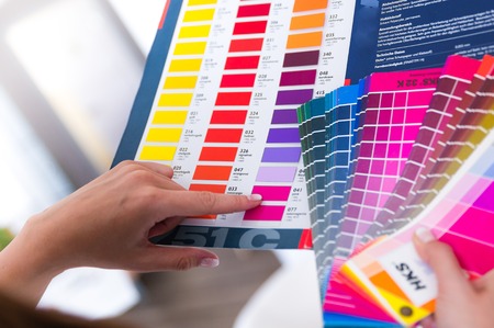 graphic designer holding color fan in his handの写真素材