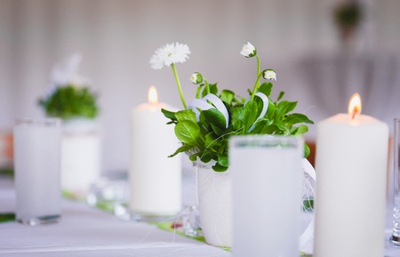 candles and daisies on Dining table setting lightの写真素材