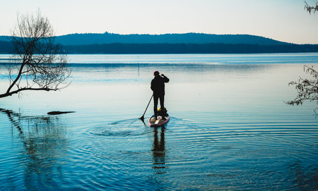 stand-up-paddler at dawn as symbol for new start and departureの写真素材