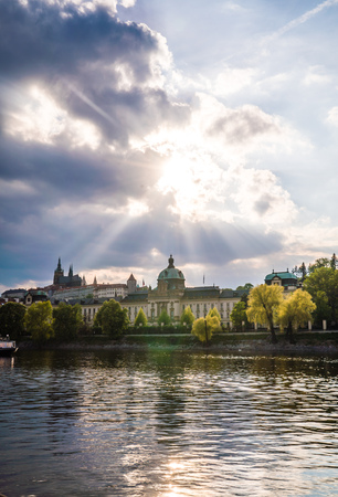 Scenic urban view of buildings, Charles Bridge, and Vltava River in the capital of the Czech Republic by the Prague Castle during sunset after a stormの写真素材