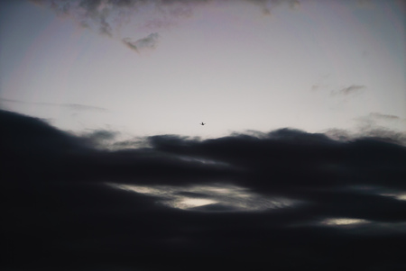 passenger plane flying in the sky through cloudsの写真素材