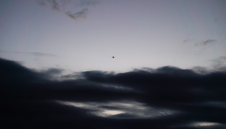 Passenger Airliner flying high in the cloudsの写真素材