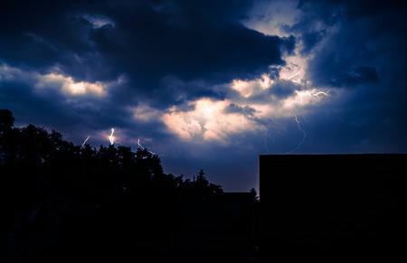 Lightning storm over city in purple lightの写真素材