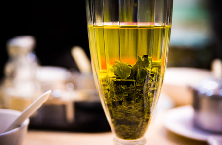 glas with tea and filled of green leafの写真素材