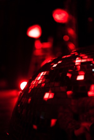 Red shining discoball with reflecting lights, mirrorball in motionの写真素材