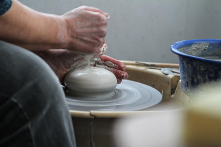 hands of a potter creating ceramic on the circleの写真素材