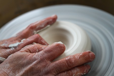 Adult female potter master preparing the clay on table. Front view, closeup, hands only, unrecognizable. Art and business, hobby and freelance working concept.の写真素材