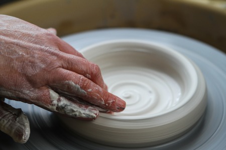 Potter works. Crockery creation process in pottery on potters' wheelの写真素材
