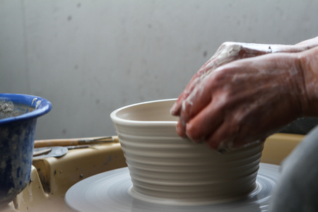 Hands of young potter, producing range of potの写真素材