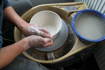 hands of a potter creating ceramic on the circleの写真素材