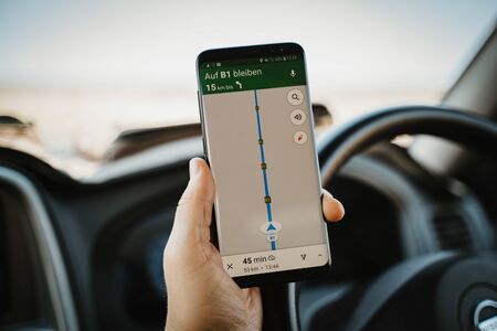 Driver using mobile phone navigation while driving carの写真素材