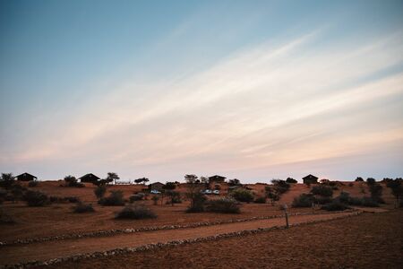 several houses and cars at an African ranch at eveningの写真素材