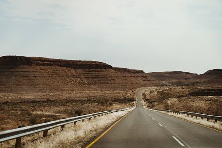 lonely street through canyon in Namibia, Africa from Keetmanshoop towards Luederitzの写真素材
