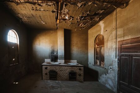 abandoned old kitchen in ruined partially collapsed buildingの写真素材