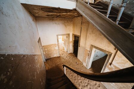 Old staircase in abandoned house filled with sand, Kolmanskop Ghost Townの写真素材