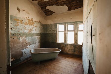 Old bathtube in ruins of Kolmanskop located in the Namib desert near Luderitzの写真素材