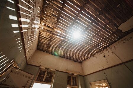Damaged Building Roof with sunlight shinigh throughの写真素材
