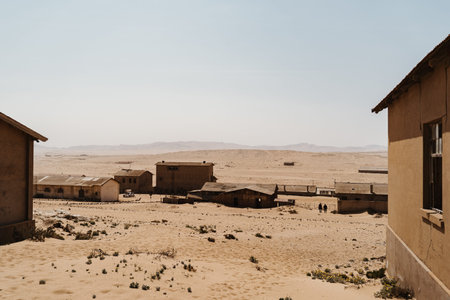 Abandoned buildings left to rot in wild west scenery with desert sand