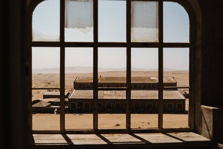 View outside and old desert building on to other abandoned houses in the sandの写真素材