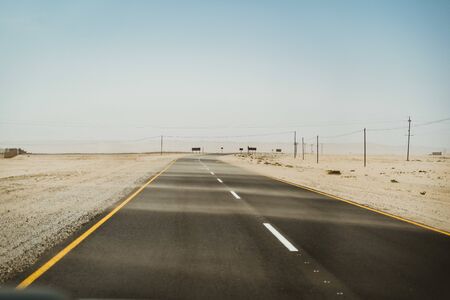 long road next to the Sahara desert during a sandstormの写真素材