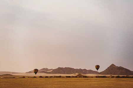 Hot air balloons flying in morning at desertの写真素材