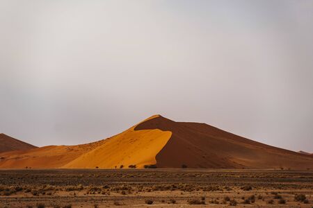 Tourists climb desert Dune No45 Namibia, Africaの写真素材