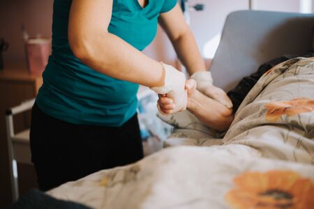 old patient on bed with doctor holding hands for nursing, medical health careの写真素材