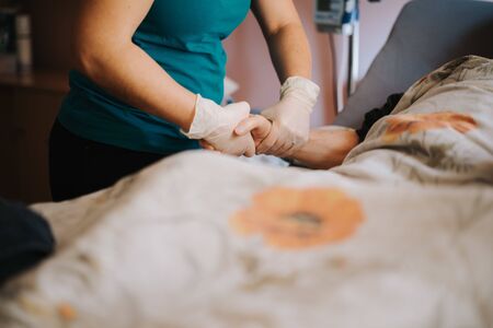 old patient on bed with doctor holding hands for nursing, medical health careの写真素材