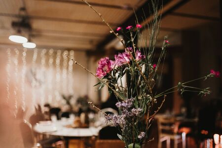 beautiful flower arrengments for a wedding with blurry table in backgroundの写真素材