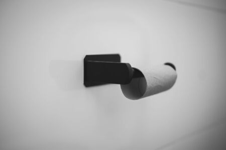 Empty Toilet paper roll on wall in bathroom, black and whiteの写真素材