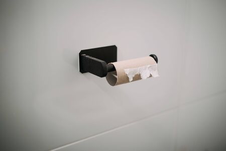 Empty Toilet paper roll on wall in bathroomの写真素材